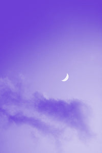 Photograph of a violet night sky illuminated by the moonlight
